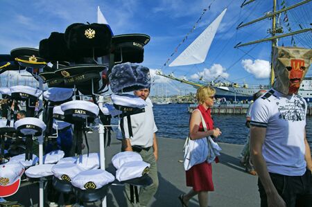 ST PETERSBURG - JULY 12: Young men walk by street vendor place and play fools at regatta festival near Neva river July 12, 2009 in St Petersburg, Russia.のeditorial素材