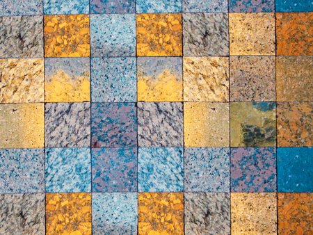 Checked pattern of various kinds of natural stone. A fragment of faced wall. Squares of grey, blue...