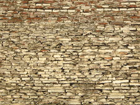 Textured background of a grey-brown brick wall of irregular bricksの写真素材