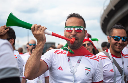 Football fans of Iran at 2018 FIFA world cup in Russia. A wan in glasses colored as iranian flad is...