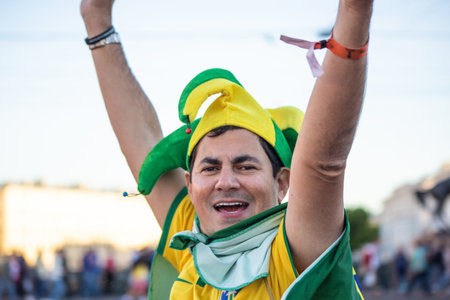 Still happy football fan of Brasil in a yellow and green hat raised his arms. St. Petersburg, Russia. July 2018, FIFA world cup.のeditorial素材