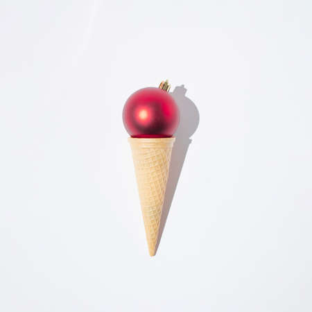 Christmas decoration in ice cream cone on white background. New Year minimal concept. Creative idea.の写真素材