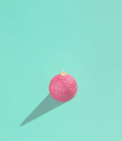 Red Christmas bauble decoration on background. Minimal Christmas concept.の写真素材