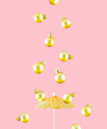 Golden Christmas decorations fall on an umbrella. Creative minimal concept. Pastel background.の写真素材
