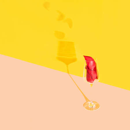 A glass full of red rose petals on a pastel background. Creative love minimal conceptの写真素材