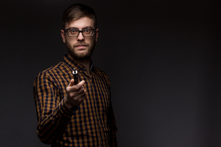 man with a beard wearing glasses on black background smoke Vape. large portrait of man. electronic cigarette. E-cigarette for vaping. Popular devices of the year - modern device. Stop smokingの写真素材