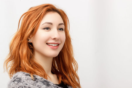 Young beautiful businesswoman successful. Portrait of a beautiful young woman. Beautiful girl with red hair in black dress. Business style. Space for text next to the womanの写真素材