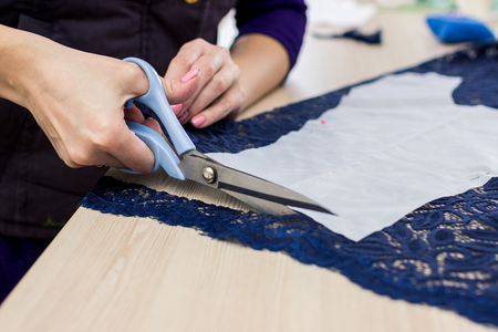 Tailor. Woman Hands notch tailor tailor's scissors cloth. Close Up.の写真素材