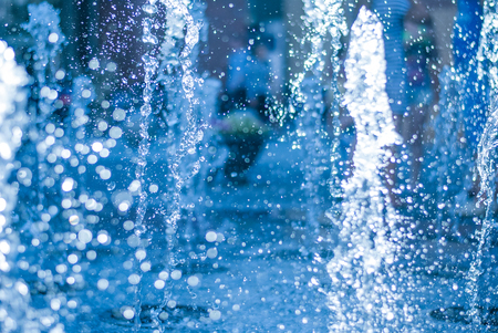 The gush of water of a fountain. Splash of water in the fountain, abstract image. bokeh of blue waterの写真素材