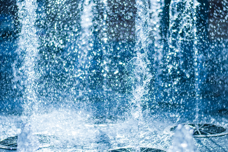 The gush of water of a fountain. Splash of water in the fountain, abstract image. bokeh of blue waterの写真素材