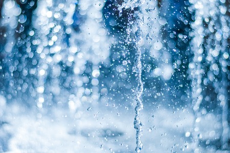 The gush of water of a fountain. Splash of water in the fountain, abstract image. bokeh of blue waterの写真素材