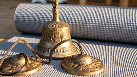 yoga bell is lying on the meditation matの写真素材