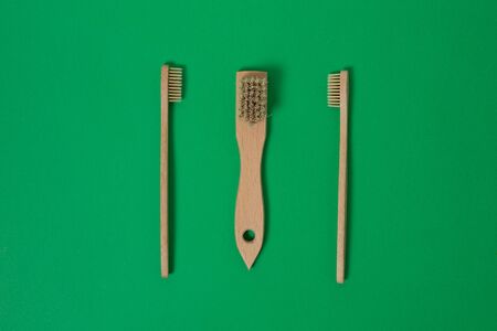Wooden bamboo toothbrushes isolated on a green background