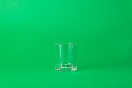 and empty faceted glass on a green backgroundの写真素材