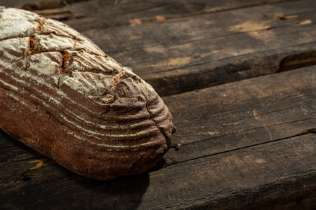 Fresh baked bread at brown wooden table. brown coarse grain bread
