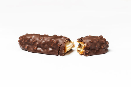 Broken chocolate bar with dark brown chocolate with nuts on a white background.