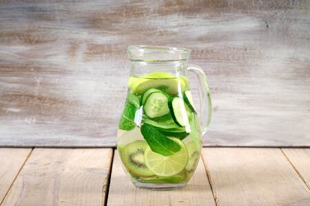 lemonade drinks with slices of lime on the glass, and carafe. Slices of lime, ice and mint leaves on a white wooden background. Copy space.の写真素材