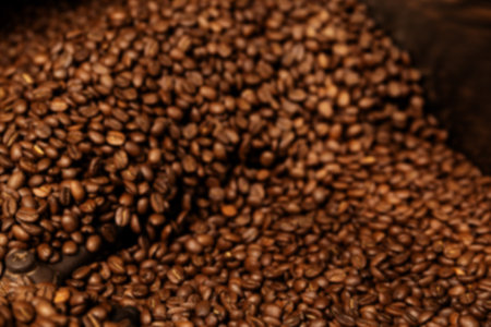 Fresh Roasted Natural Coffee Beans Cascading out of Industrial Coffee Bean Roaster Machine Inside the Coffee Shopの写真素材