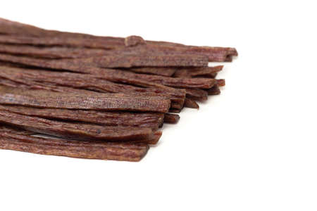 Dried beef meat sliced on stick, beer snack isolated on white backgroundの写真素材