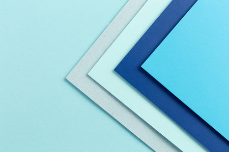 Material design blue background. Craft paper sheets are folded in different ways. A photo