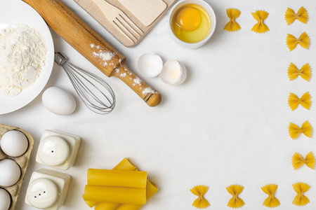 Raw pasta with ingredients on the white table. Top view. Different kinds of pasta. Various types of pasta. Italian cuisine. Free space for text. Pasta background. Flour and eggsの写真素材