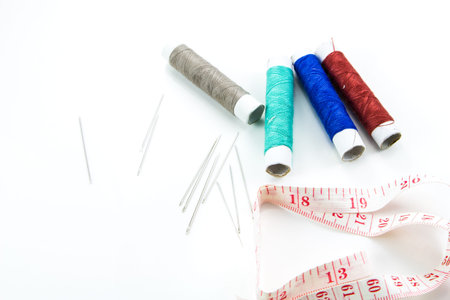 Spool of thread, needle on white background