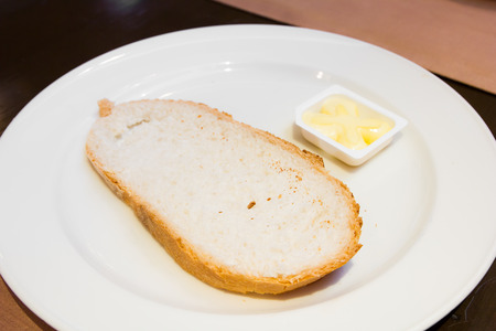 bread and butter on white dishの写真素材