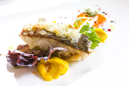 baked fish with sauce on white plate