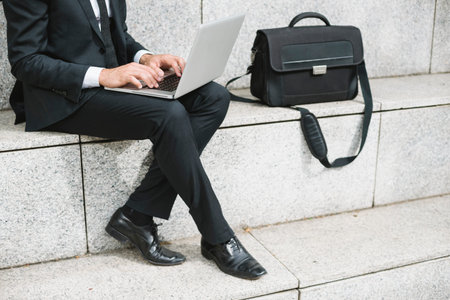 Business sitting in the city working at laptop