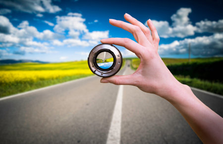 Hand holds green logistics symbol against road