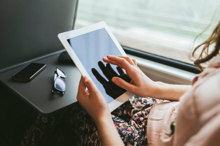 Woman using a digital tablet traveling by train