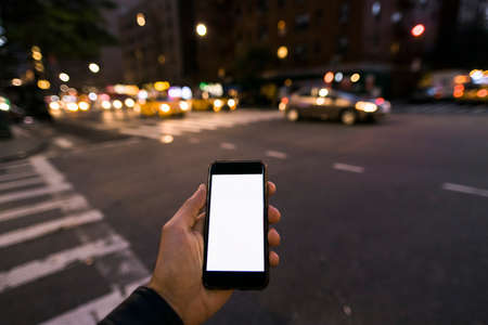 hand holding phone at night in the cityの写真素材