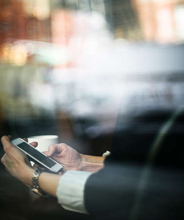 Businesswoman using a phone in a cafeの写真素材