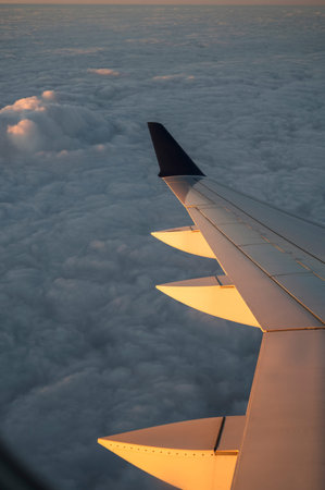 Airplane Wing Over Cloudscape at Sunrise