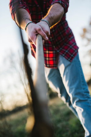 Man chopping wood with axe in rural fieldの写真素材