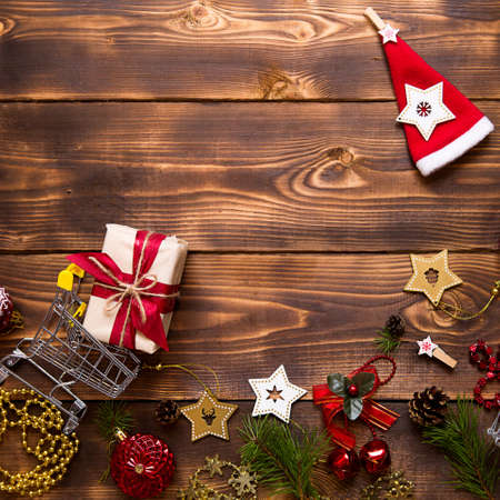 Christmas flat lay on the theme of shopping, buying gifts for the new year. Black Friday, sale, decor of stars, spruce branches, ball, beads, garlands, cones on a wooden background. Space for textの写真素材