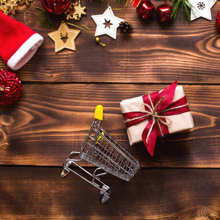 Christmas flat lay on the theme of shopping, buying gifts for the new year. Black Friday, sale, decor of stars, spruce branches, ball, beads, garlands, cones on a wooden background. Space for textの写真素材