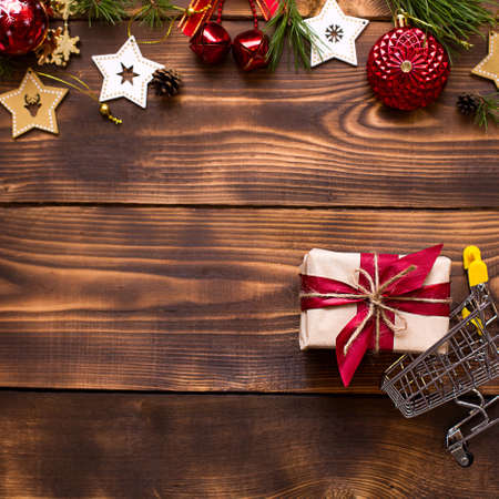 Christmas flat lay on the theme of shopping, buying gifts for the new year. Black Friday, sale, decor of stars, spruce branches, ball, beads, garlands, cones on a wooden background. Space for textの写真素材