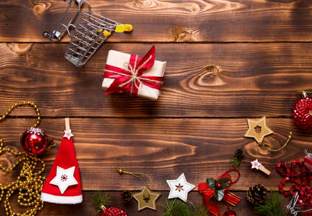 Christmas flat lay on the theme of shopping, buying gifts for the new year. Black Friday, sale, decor of stars, spruce branches, ball, beads, garlands, cones on a wooden background. Space for textの写真素材