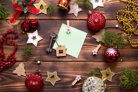 Christmas flat lay on a wooden background with keys to a new house in the center with a place for notes. New year, transfer, shares of the mortgage, the rental of a cottage. Space for text, to do listの写真素材