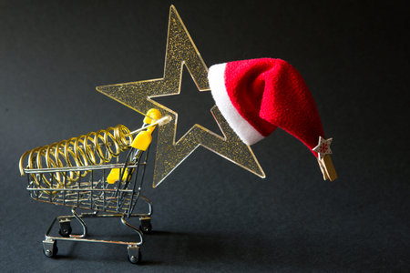 Shopping cart with a gold transparent star with sequins in the shape of a Christmas tree on a black...