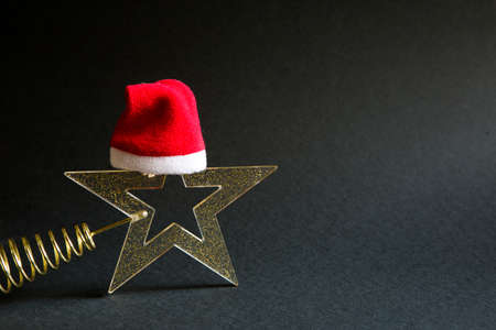 Gold transparent star with spangles in the shape of a Christmas tree on a black background. New year, Santa hat, gift, black Friday. Space for textの写真素材