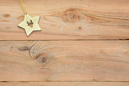 Christmas flatlay on a wooden background in rustic style: decorations made of wood in the shape of a star, spruce. Stencils in the shape of a deer, snowflakes. New year, home comfort. Space for textの写真素材