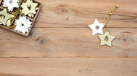 Christmas flatlay on a wooden background in rustic style: decorations made of wood in the shape of a star, spruce. Stencils in the shape of a deer, snowflakes. New year, home comfort. Space for textの写真素材