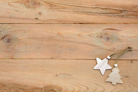Christmas flatlay on a wooden background in rustic style: decorations made of wood in the shape of a star, spruce. Stencils in the shape of a deer, snowflakes. New year, home comfort. Space for textの写真素材