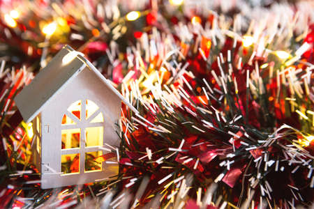 White wooden house with Christmas decorations, red tinsel and Golden lights garlands. New year, comfort, home warmth, cozy. Christmas background. Copy spaceの写真素材