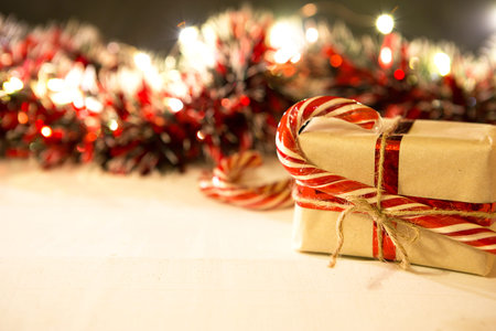 Christmas gift in a box wrapped in craft paper, tied with ribbon and rope, caramel cane. decorations...