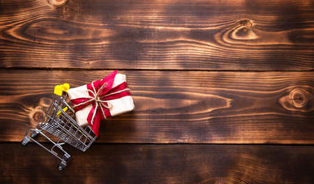 Christmas flat lay on the theme of shopping, buying gifts for the new year. Black Friday, sale, decor of stars, spruce branches, ball, beads, garlands, cones on a wooden background. Space for textの写真素材