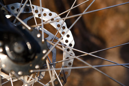 Bicycle wheel with elements closeup: disc brakes, spokes, reflector. Background on the theme of Cycling, Bicycle repair, adjustment of brakesの写真素材
