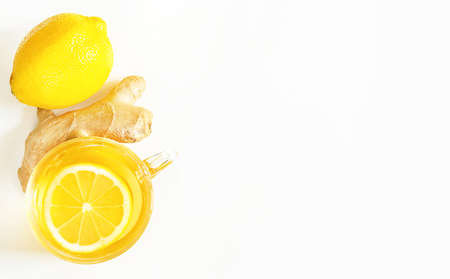 Medicinal tea in a cup, ginger, lemon-strengthen the immune system in the cold season. Vitamin drink for health and ingredients on a white background. Copy space, flatlyの写真素材